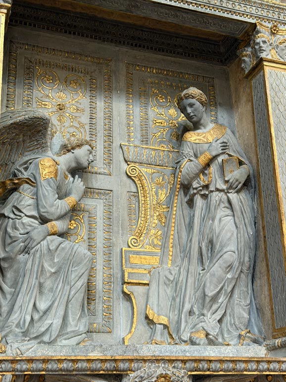 Two statues with gold highlights.