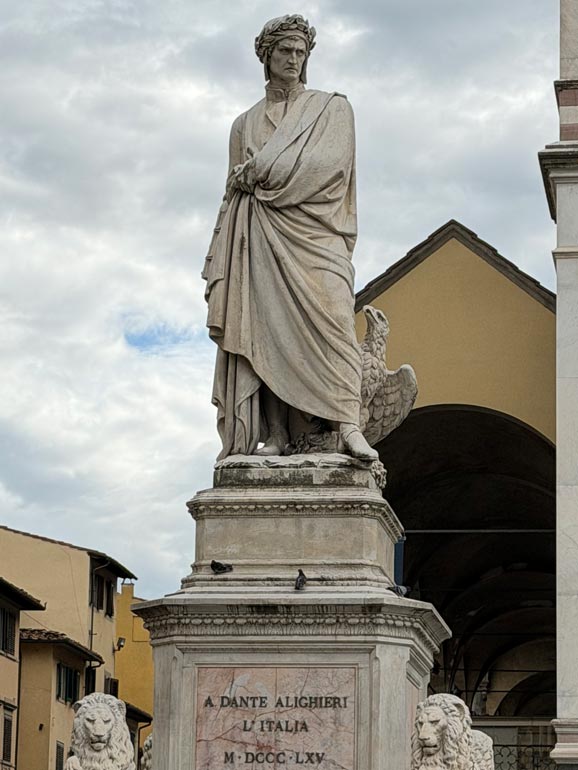 Statue of man with cloak. Eagle looking at man and two lion statues sitting at base.