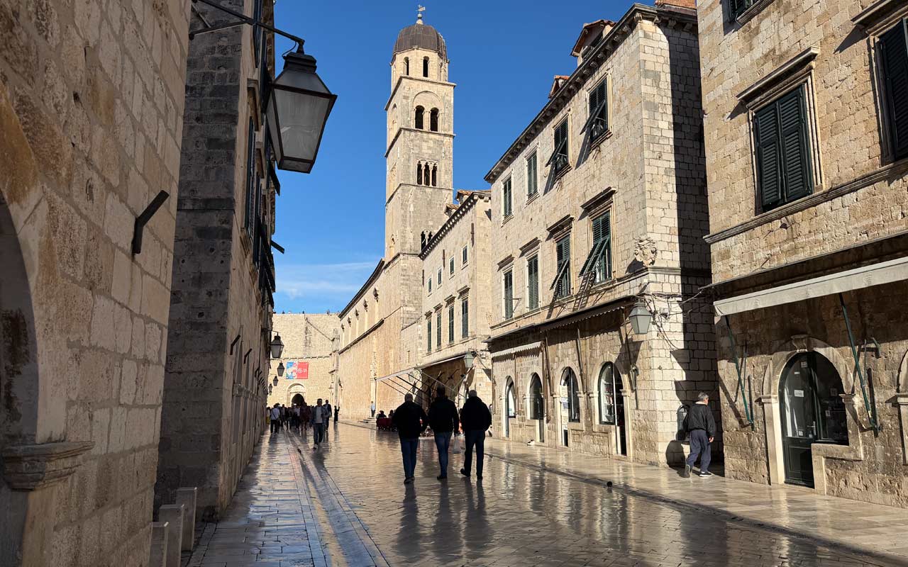 People walking along the polished limestone Stradun in the Dubrovnik Old Town