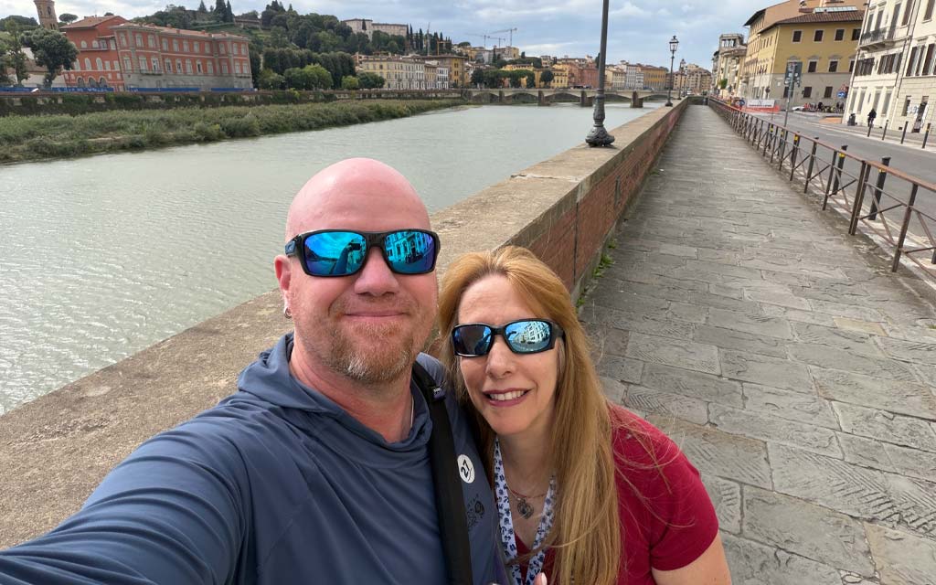 Gordon and Anna selfie with the Arno river behind them. River is gentle.