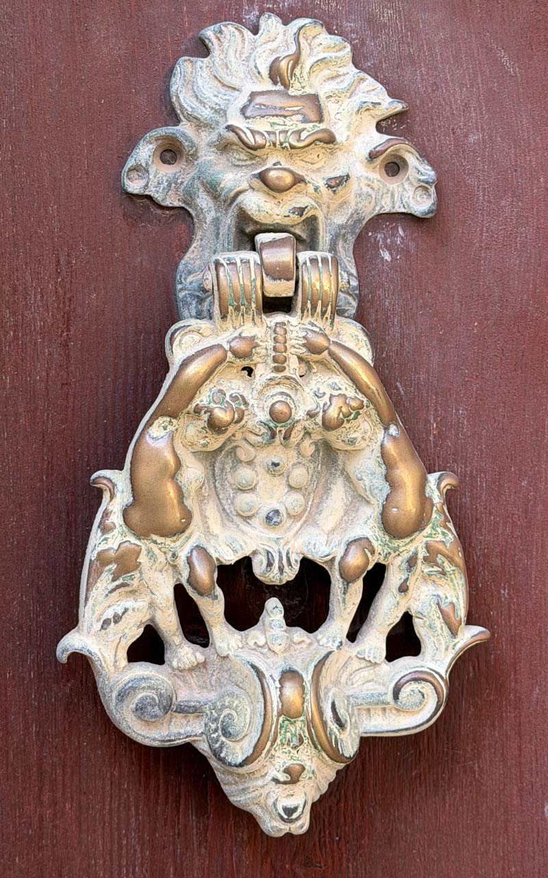 Mdina Ornate Door Knocker Mdina ornate door knockers on red door.