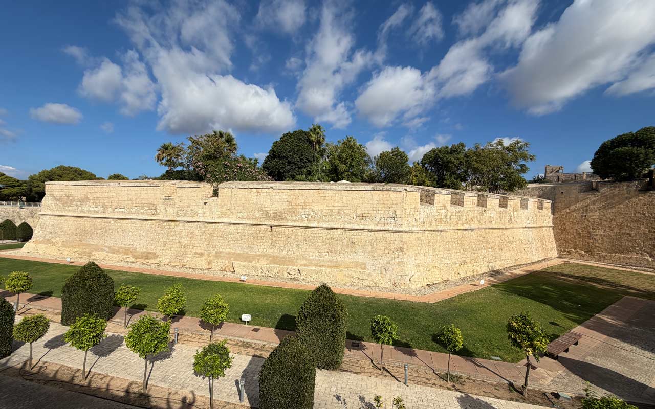 Mdina Wall Outside looking at the Mdina defensive Walls. Light yellow or tan in color with small trees.