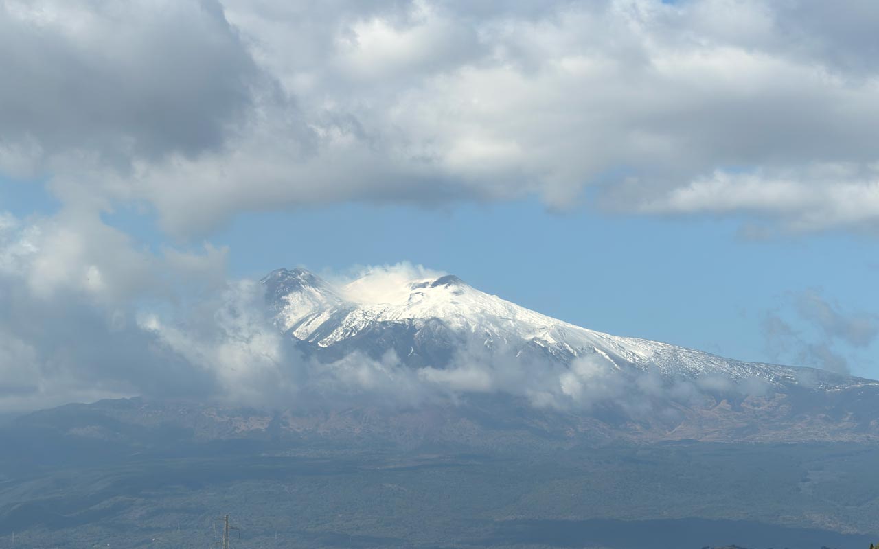 Mount Etna Mount Etna with clouds in the sky.