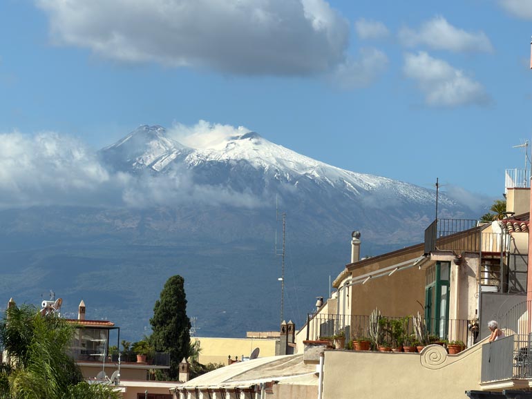 Mt Etna from Piazza IX Aprile Mount Etna in the background with buildings in the front.