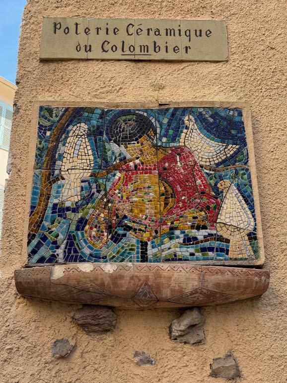 Poterie Céramique du Colombier A pottery mosaic on the side of a building.