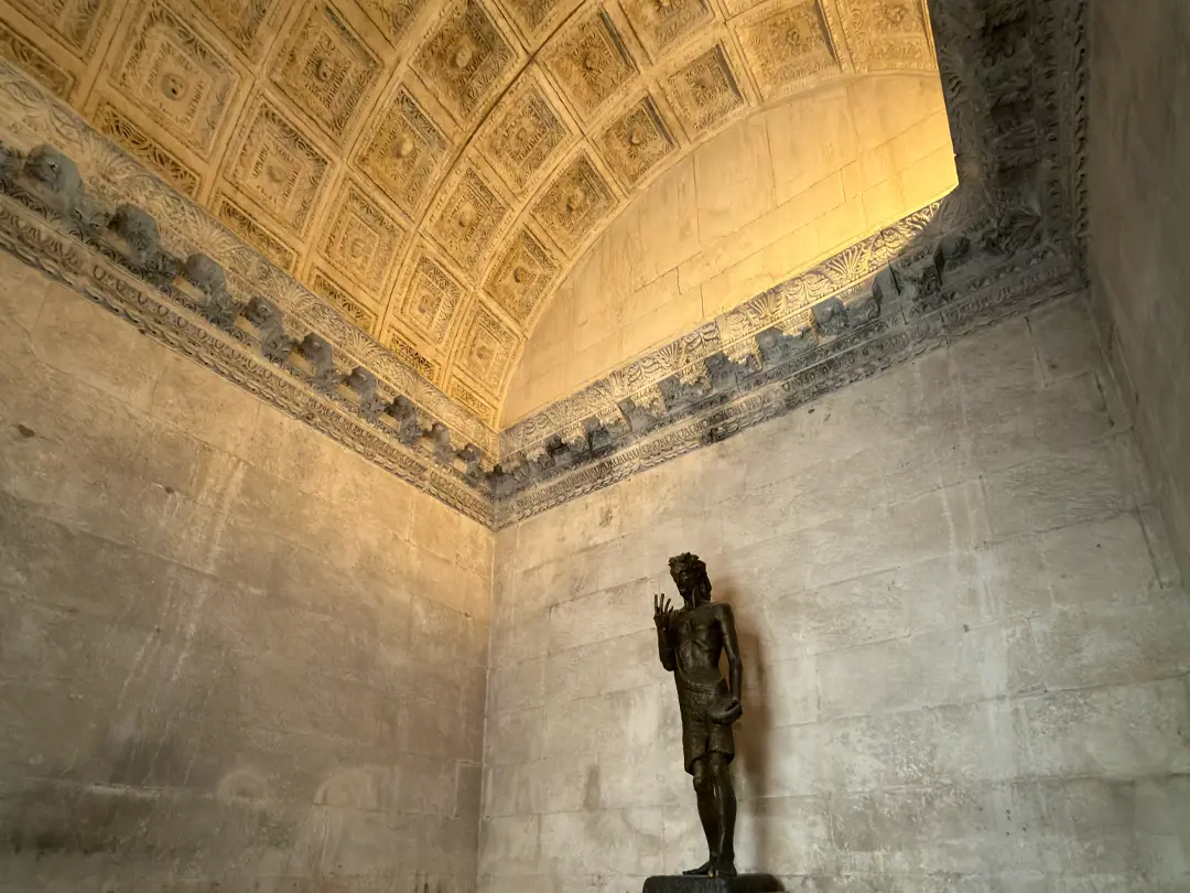Inside the Temple of Jupiter with John the Baptist statue. Yellow light on the ceiling.