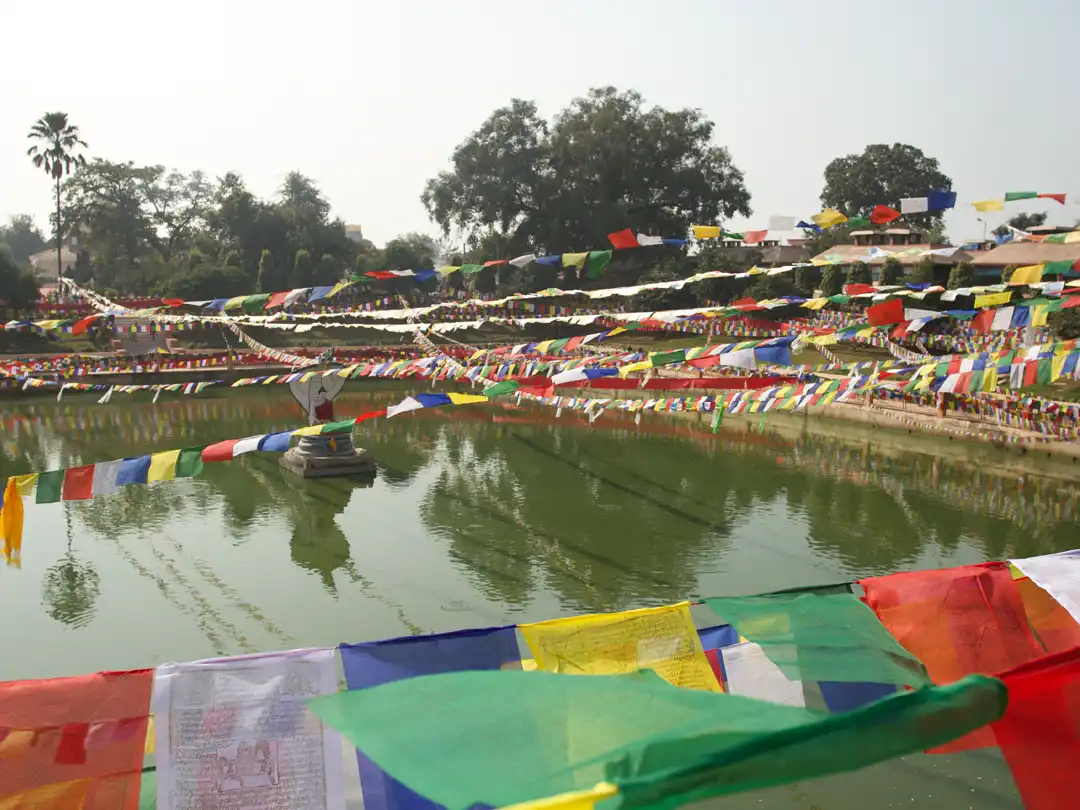 Tibetan Prayer flags hanging over Muchalinda Lake with the Naga protecting the Buddha